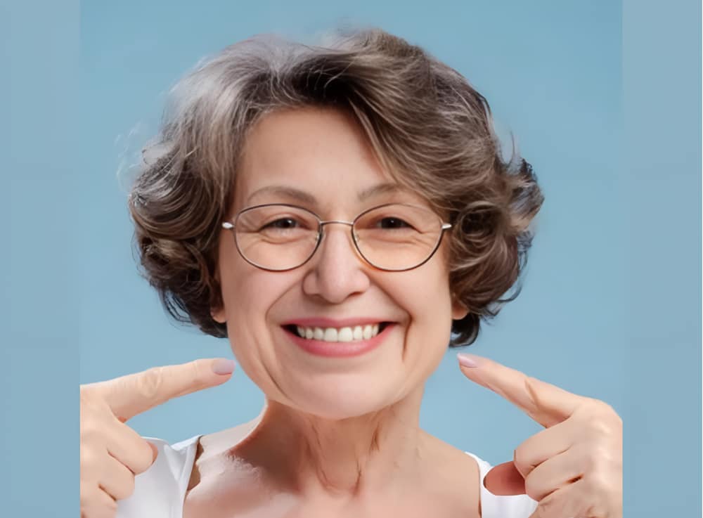 Dental patient smiling while pointing at teeth