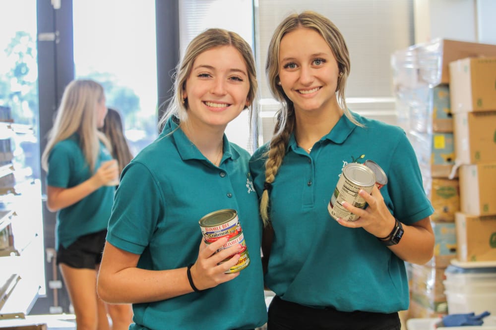 volunteers holding canned food